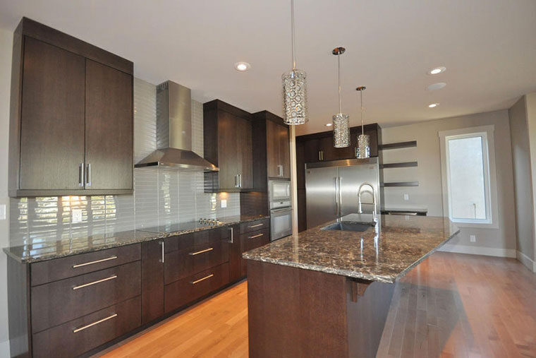 Dark cabinetry kitchen with granite island