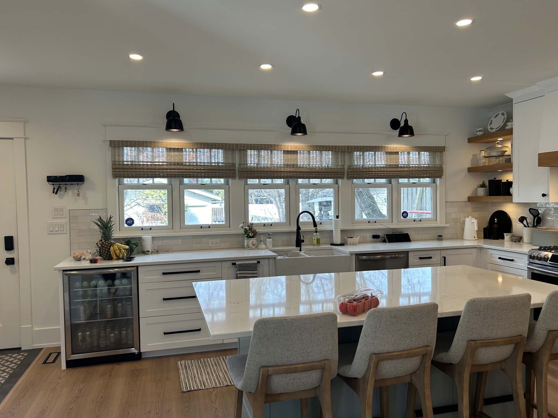 White kitchen with a large island and window seating