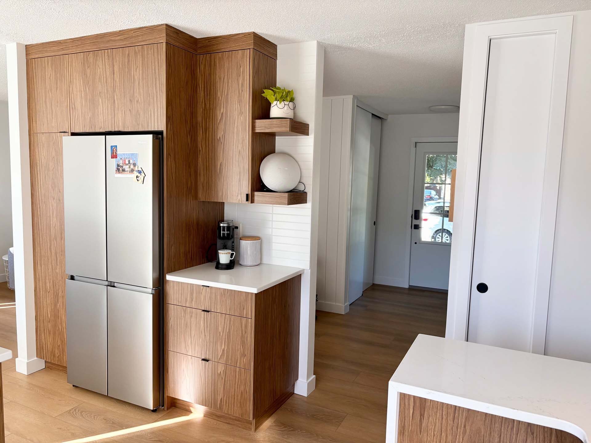 Custom walnut cabinetry beside a built-in fridge