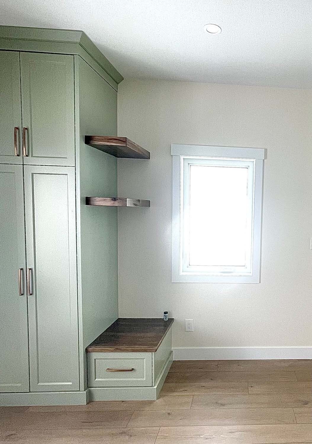 Custom walk-in closet with shelving and a window bench