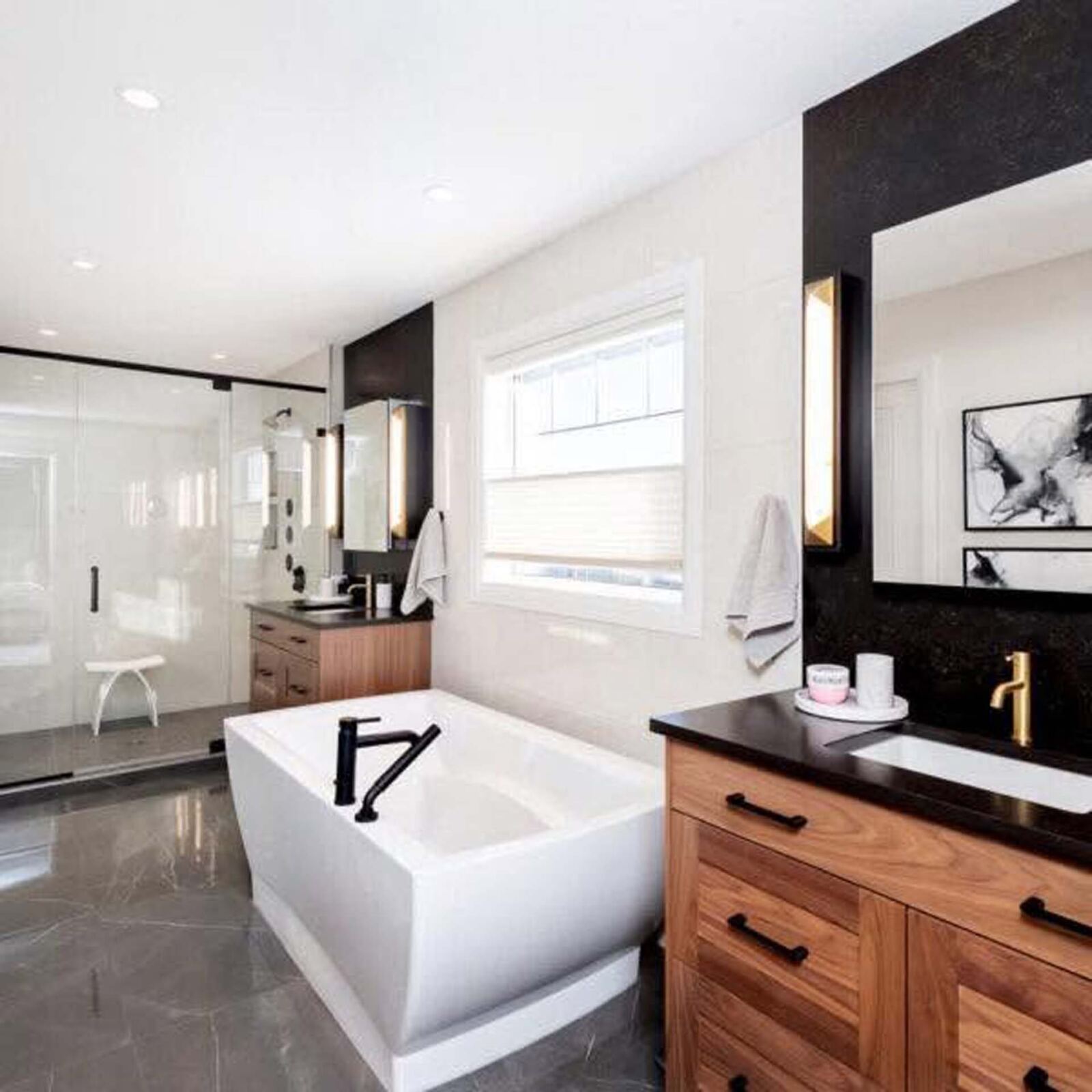 Double vanity with freestanding tub and dark stone accents