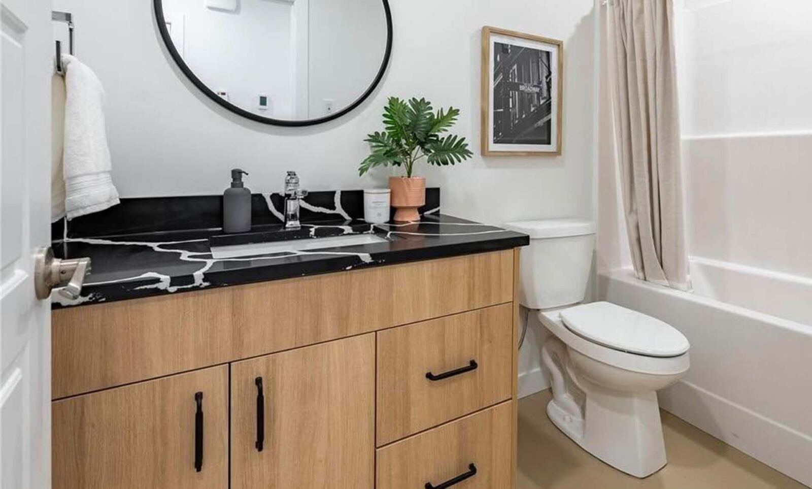 Compact vanity with rounded basin and dark counter